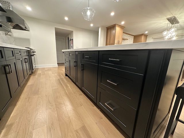 A kitchen with black cabinets and a large island.