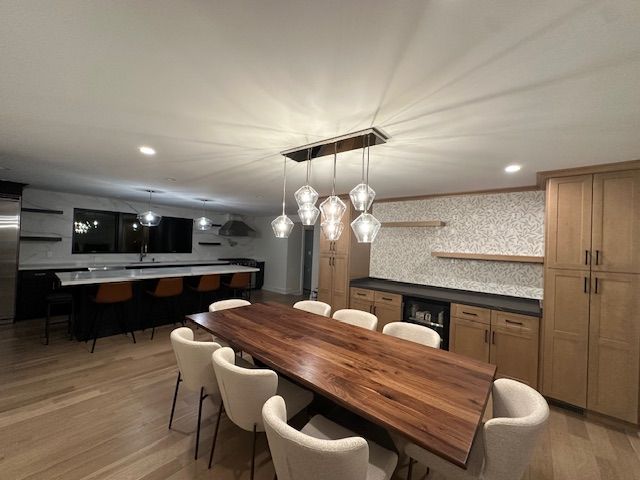 A dining room with a long wooden table and chairs