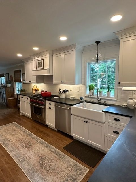A kitchen with white cabinets and stainless steel appliances