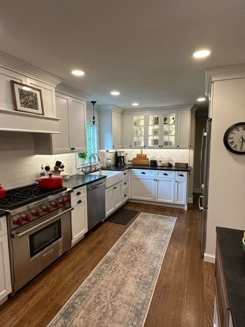 A kitchen with white cabinets and stainless steel appliances