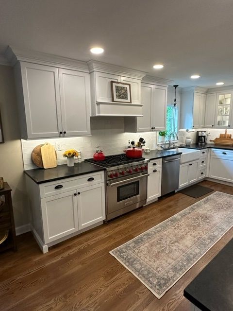 A kitchen with white cabinets and stainless steel appliances