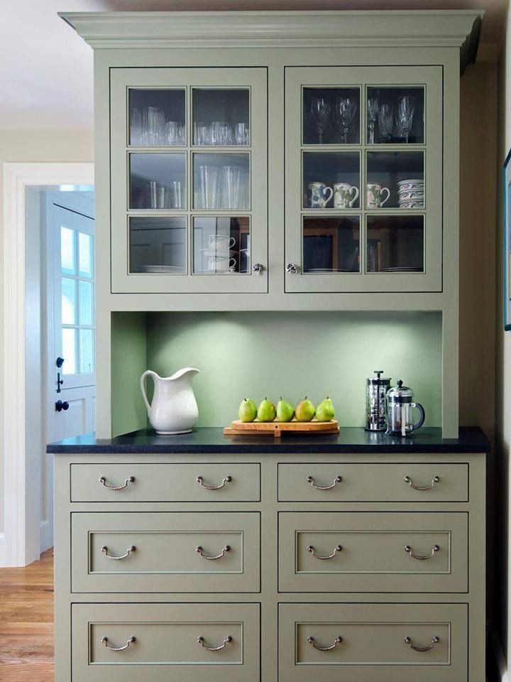 a kitchen hutch with drawers and glass doors