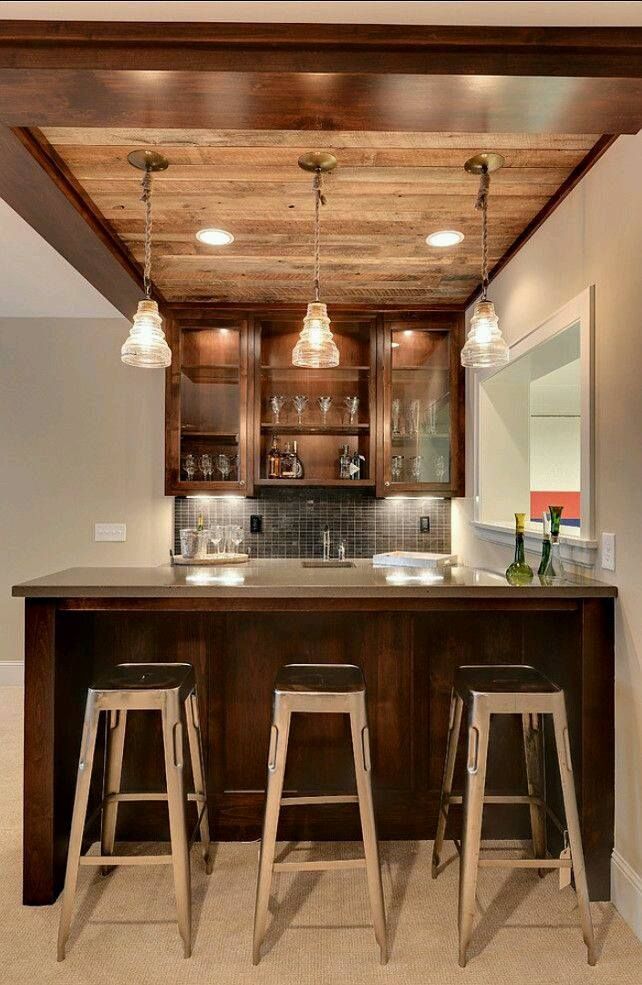a kitchen with a bar and stools and a wooden ceiling