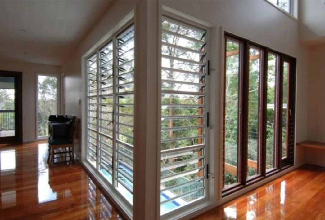 a living room with a lot of windows and shutters