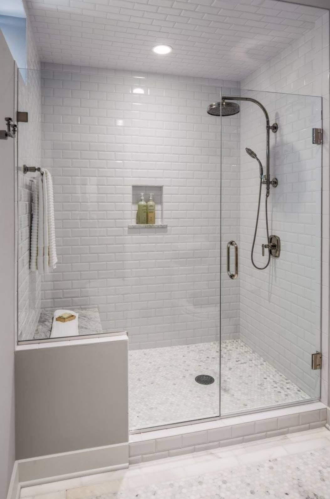 a bathroom with a walk in shower with a glass door