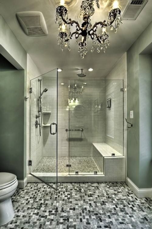 a bathroom with a walk in shower and a chandelier hanging from the ceiling