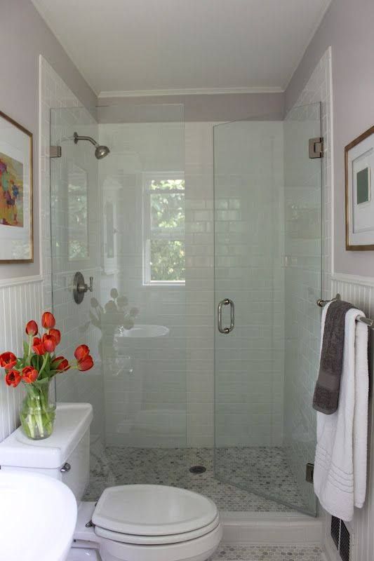 a bathroom with a toilet , sink and shower with a glass door