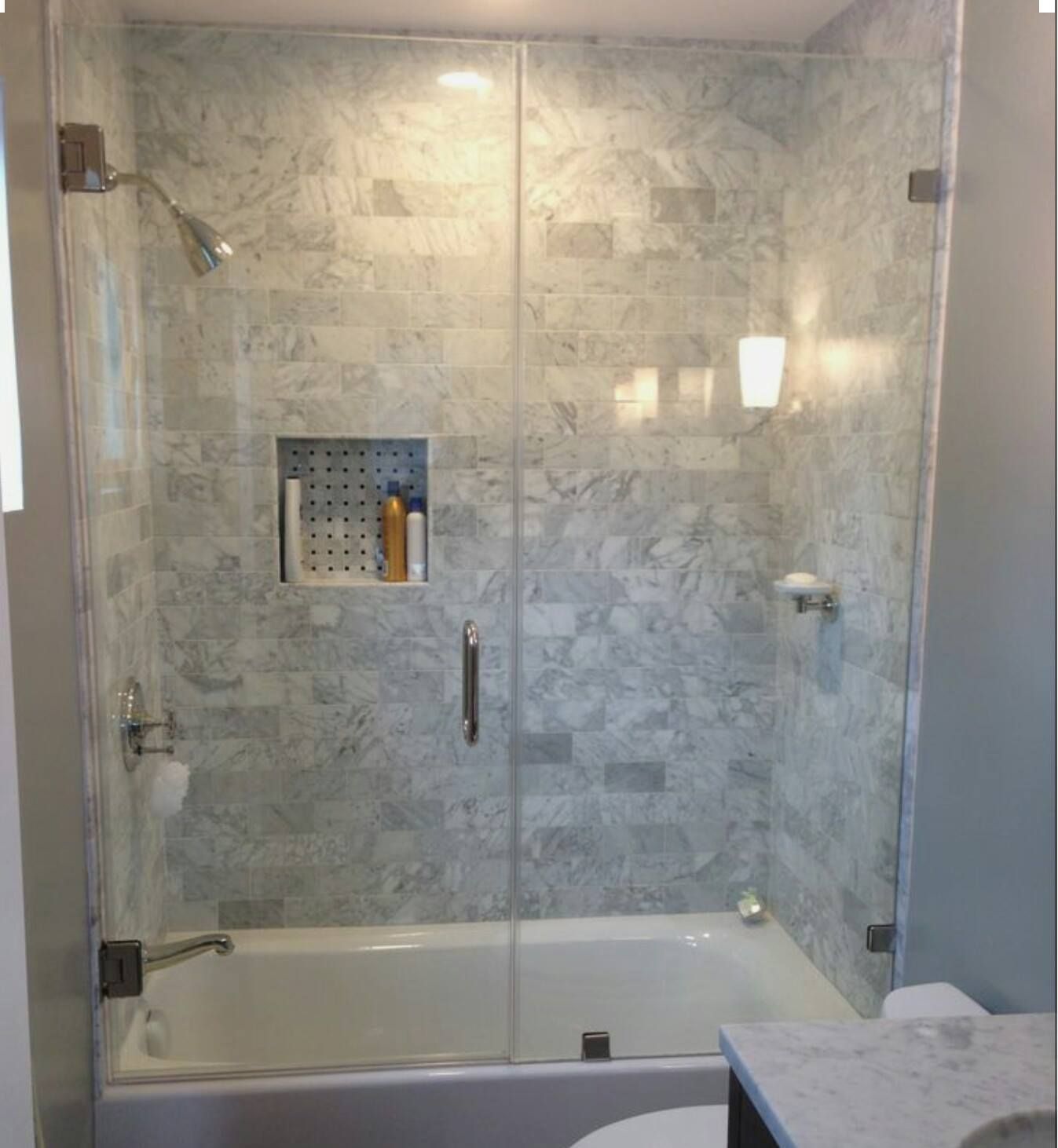 a bathroom with a bathtub and a shower with a glass door