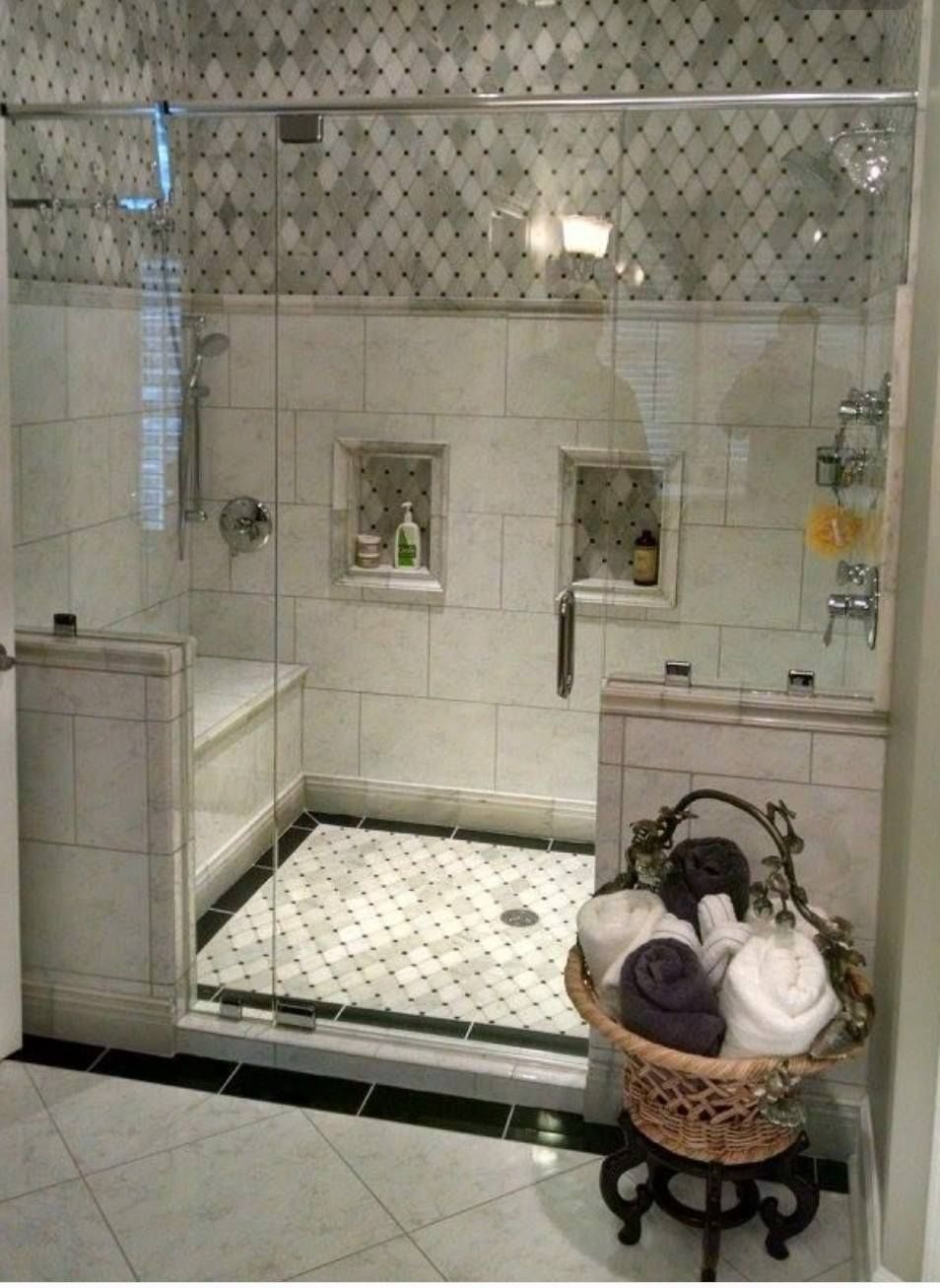 a bathroom with a walk in shower and a basket of towels