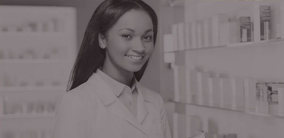 Smiling pharmacist in a white coat standing in a bright pharmacy aisle
