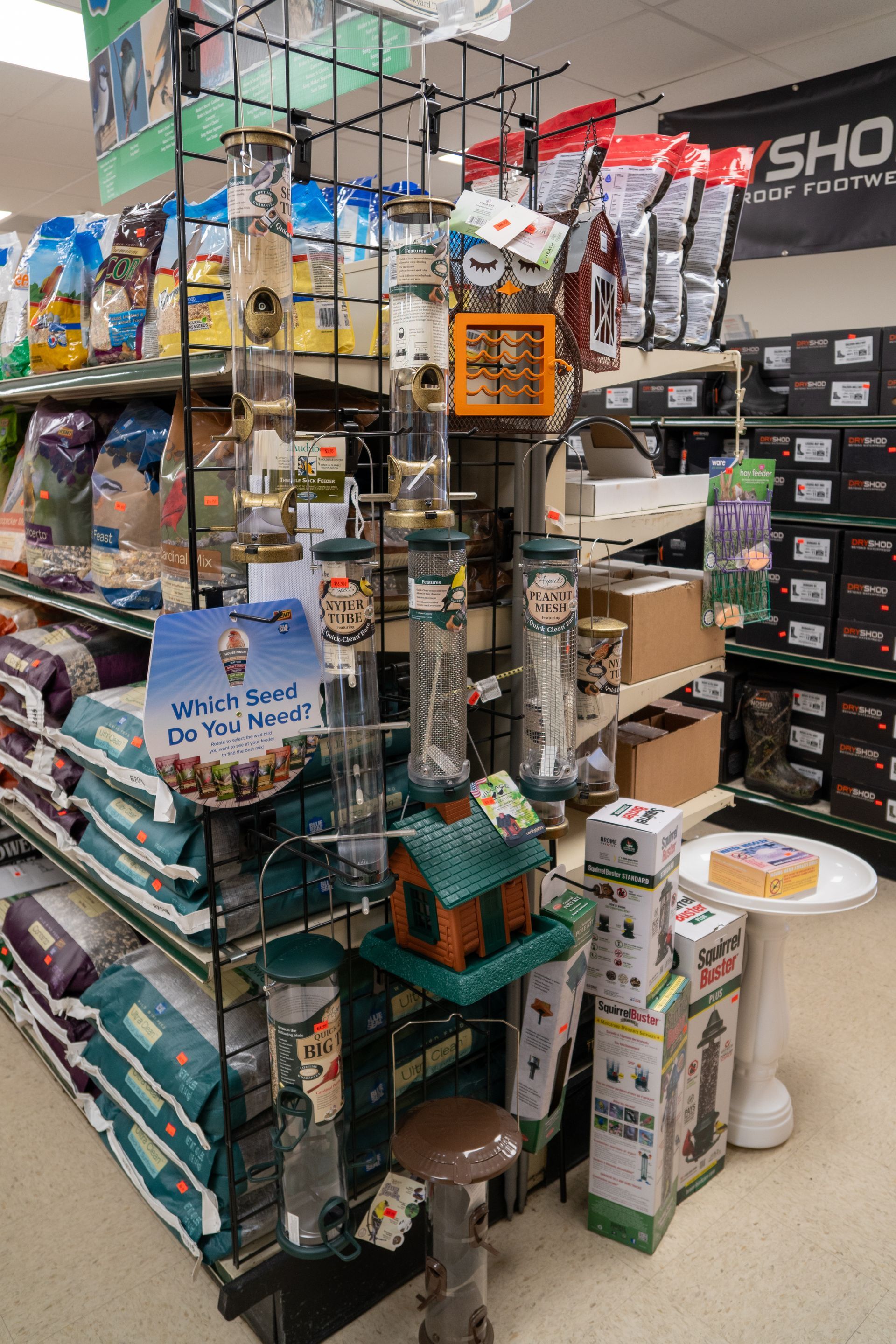 Bird feeders and bird seed on display in a retail store.