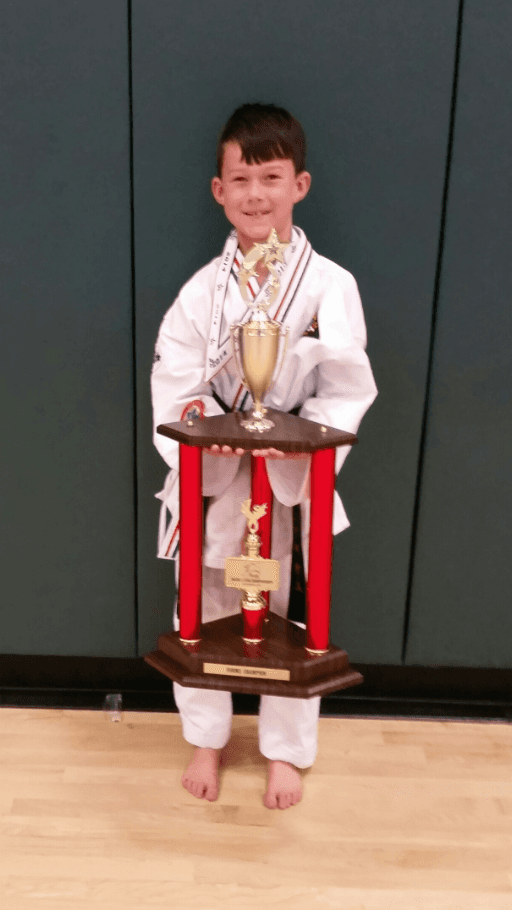 Young boy holding his trophy
