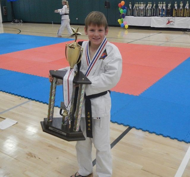 Young boy holding his trophy