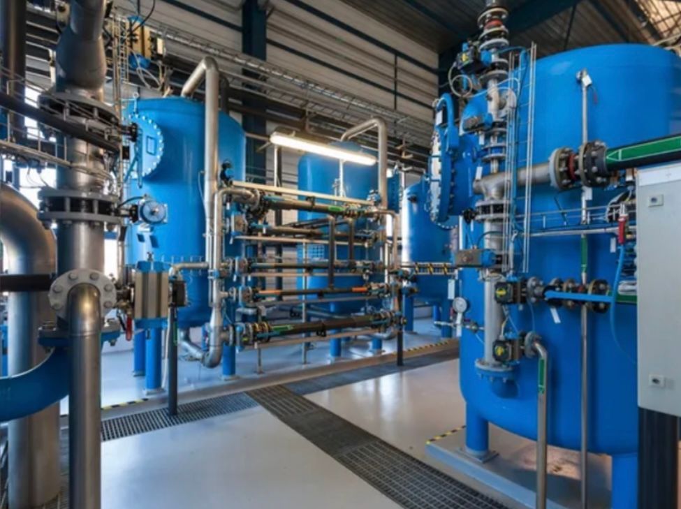 A factory filled with lots of blue pipes and tanks.