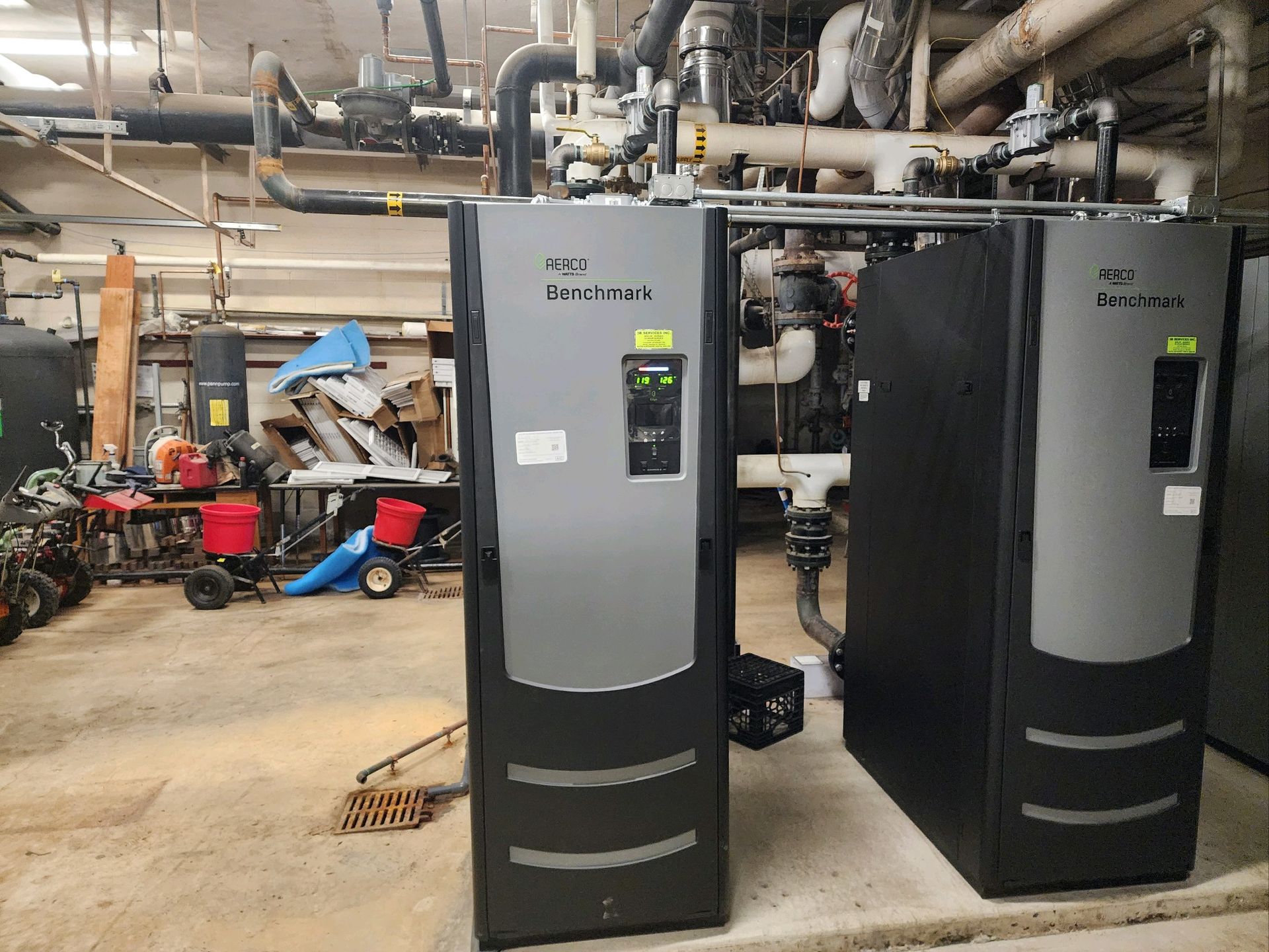 Two boilers are sitting next to each other in a room.