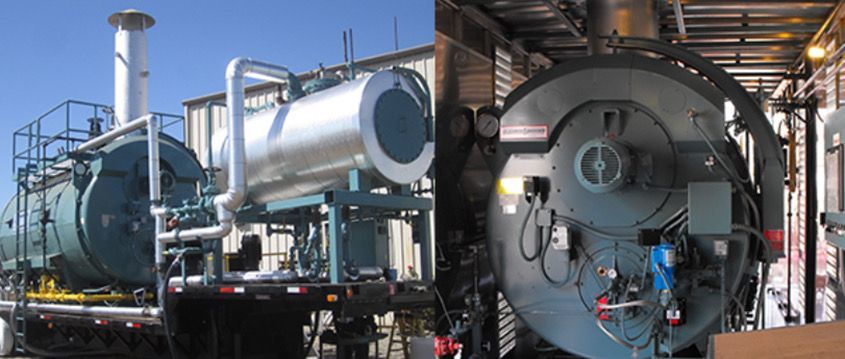 Two boilers are sitting next to each other in a factory.