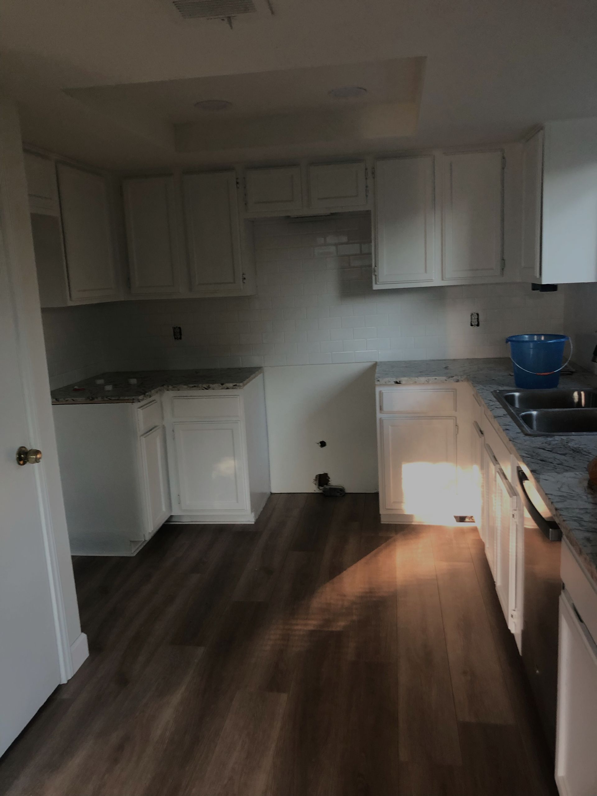 Updated Kitchen with granit countertops and a white door on the left. 