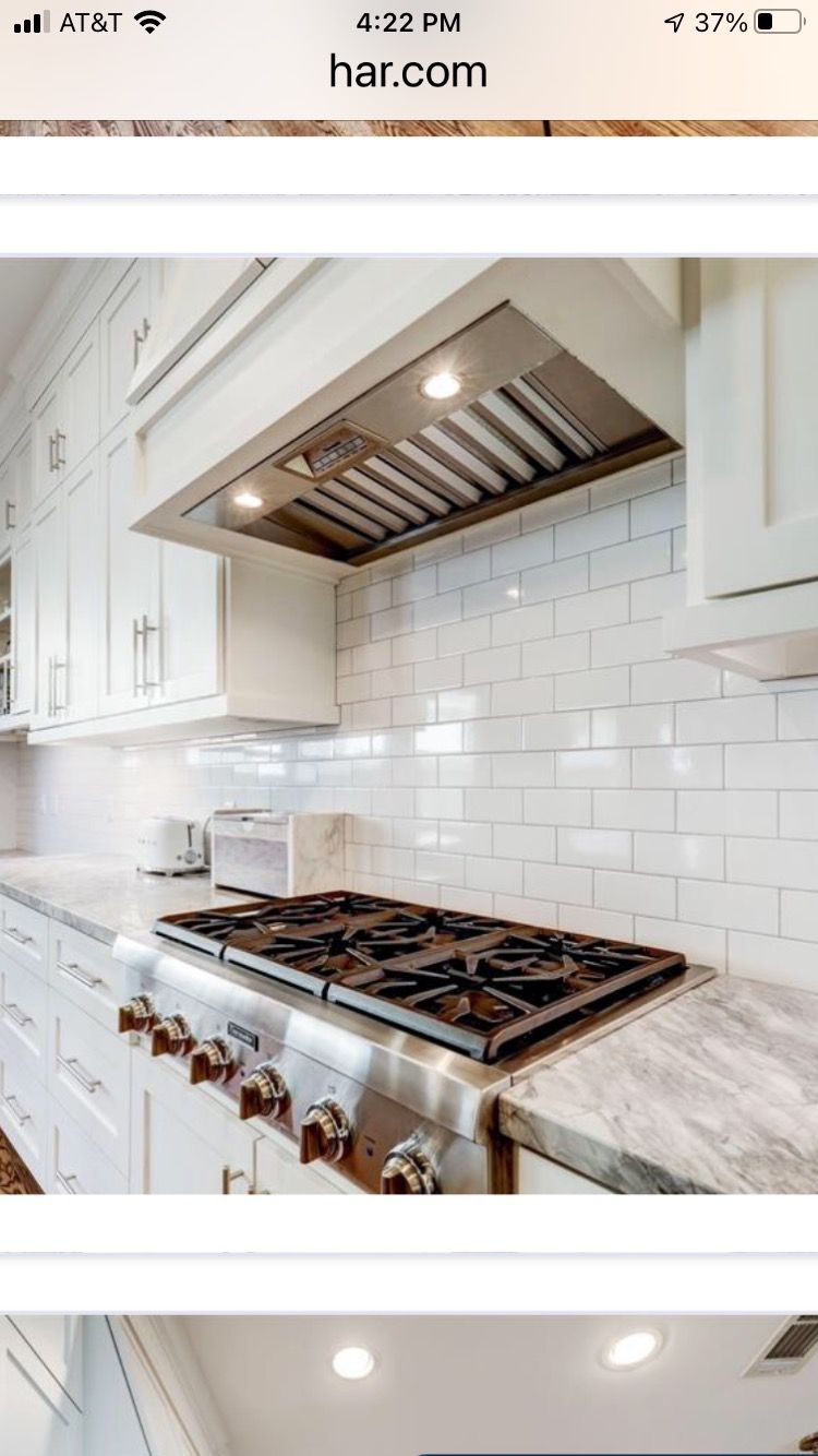 a kitchen with white cabinets and a stove top oven .