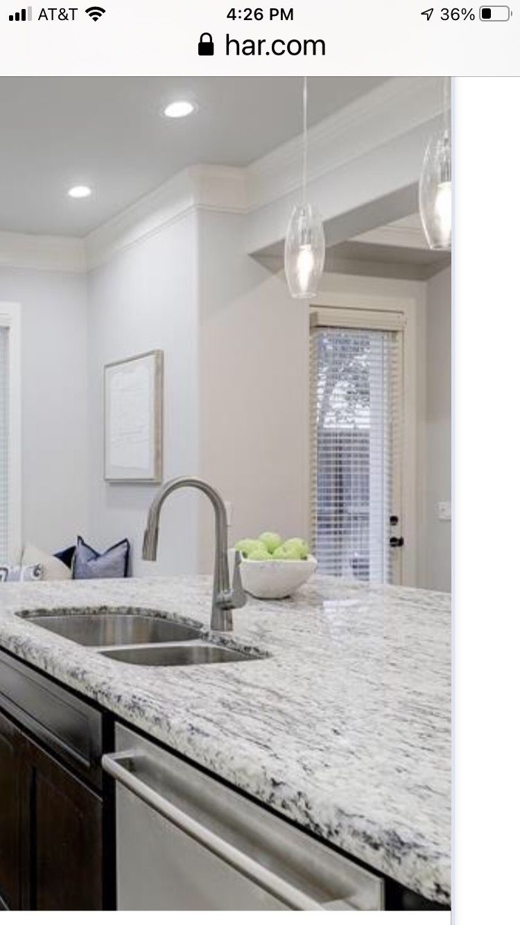 a kitchen with granite counter tops and a stainless steel sink .