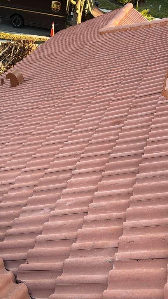 Red tile roof on a building, angled view, outdoor setting.