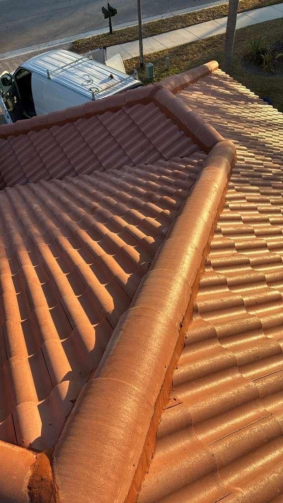 Red clay tile roof with rounded edges, in sunlight.