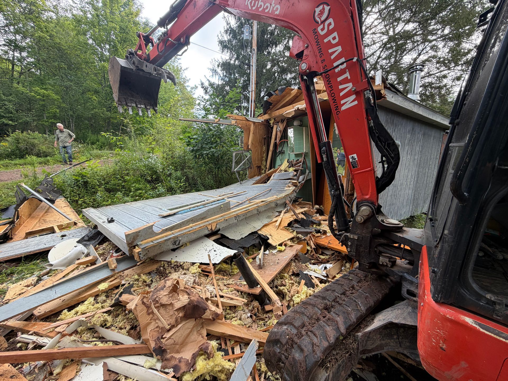 Bucket loader demolishing a mobile home
