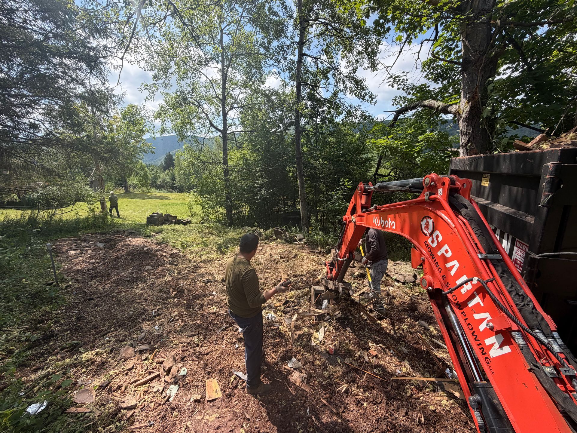 man standing near a bucket loader