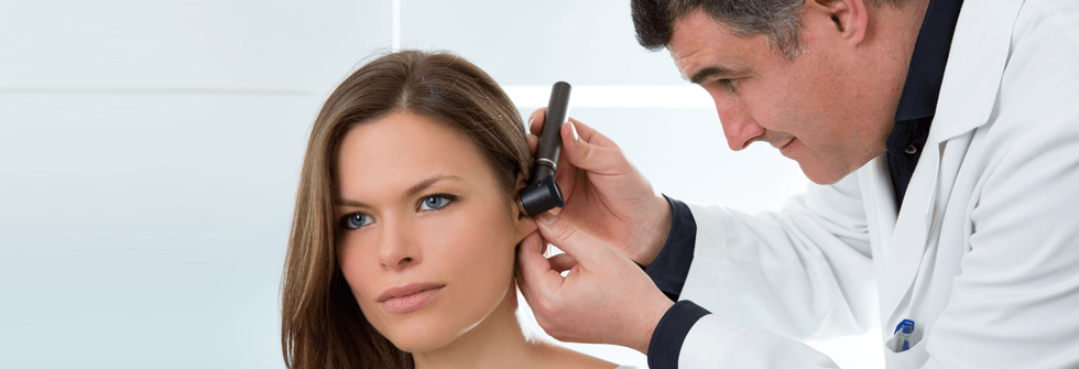 doctor checking woman's ear