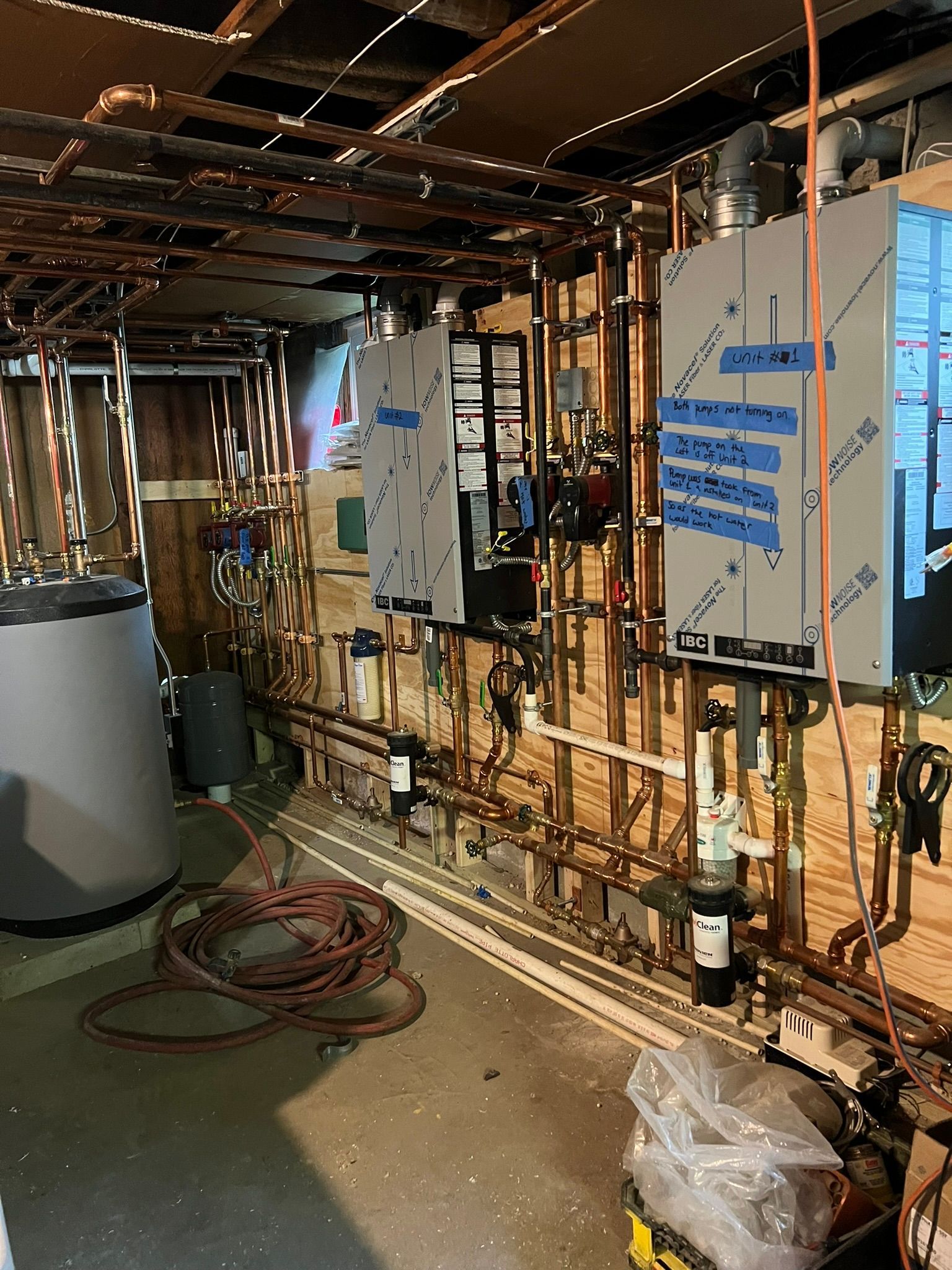 a basement with a lot of pipes and boxes on the wall