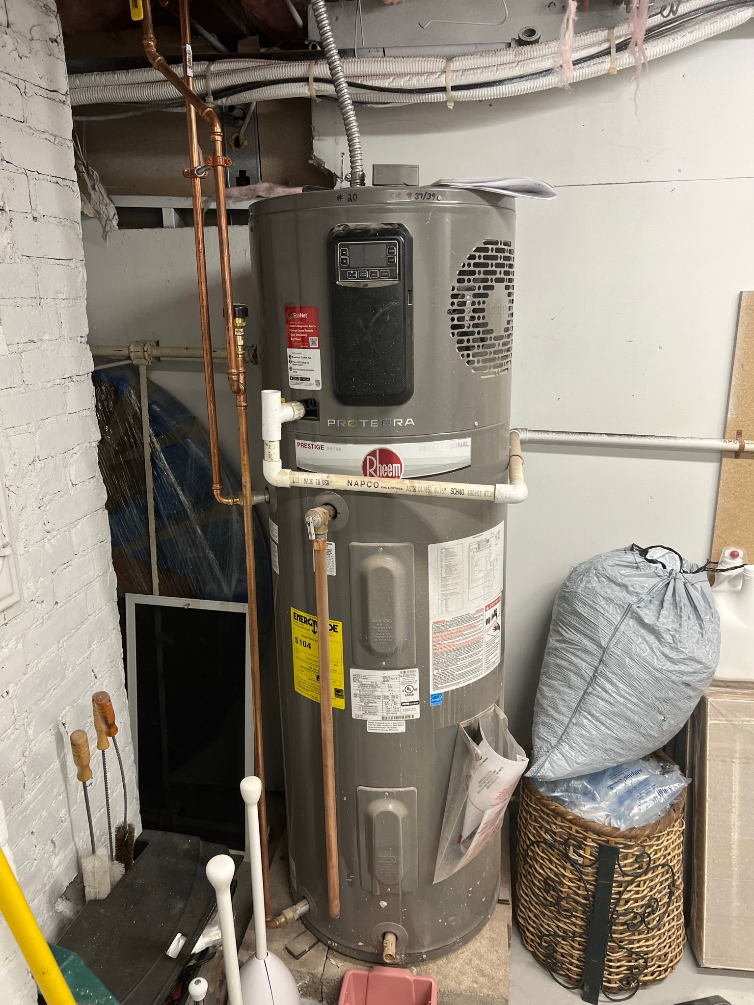 a water heater is sitting in a room next to a brick wall