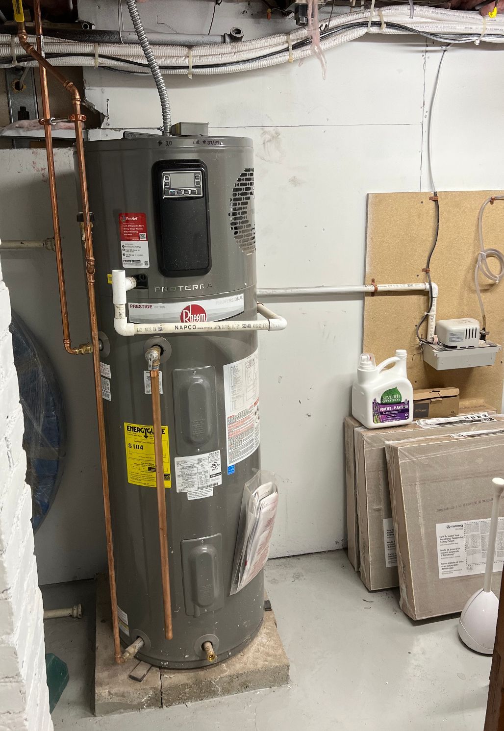 a gray water heater is sitting in a room next to a wall