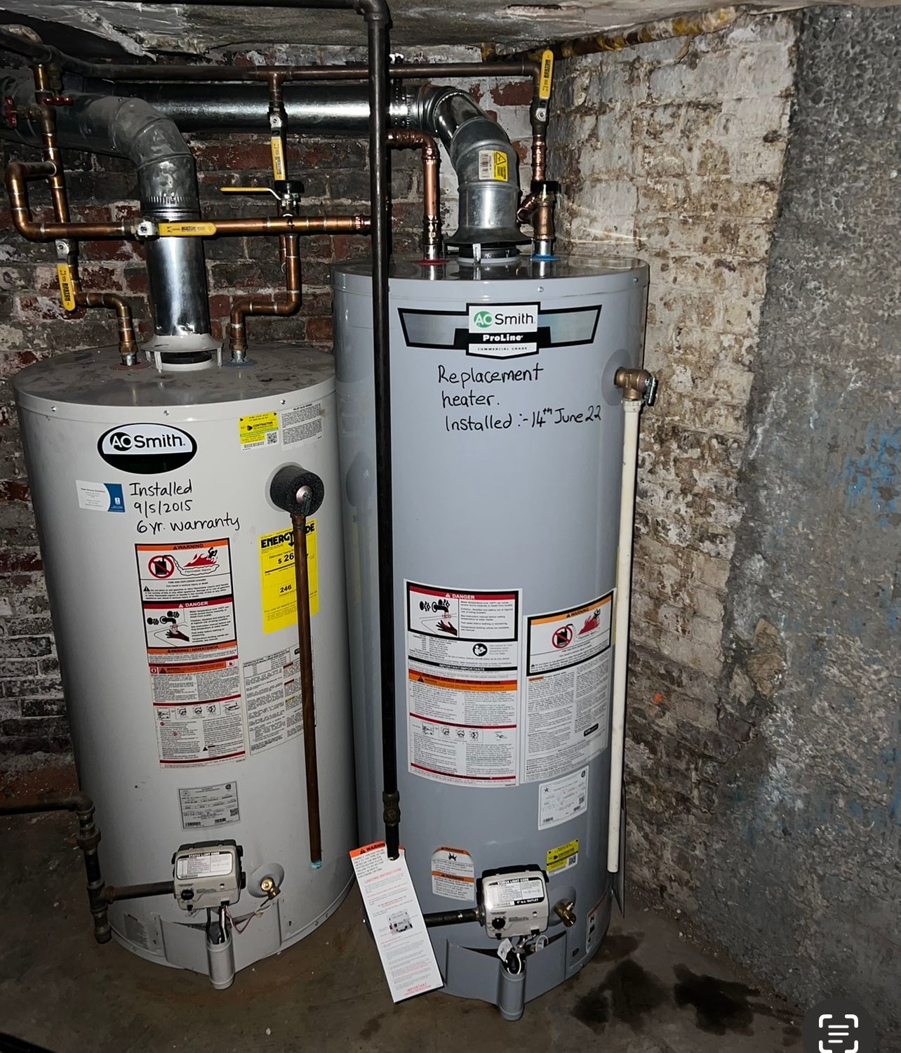 two water heaters are sitting next to each other in a basement