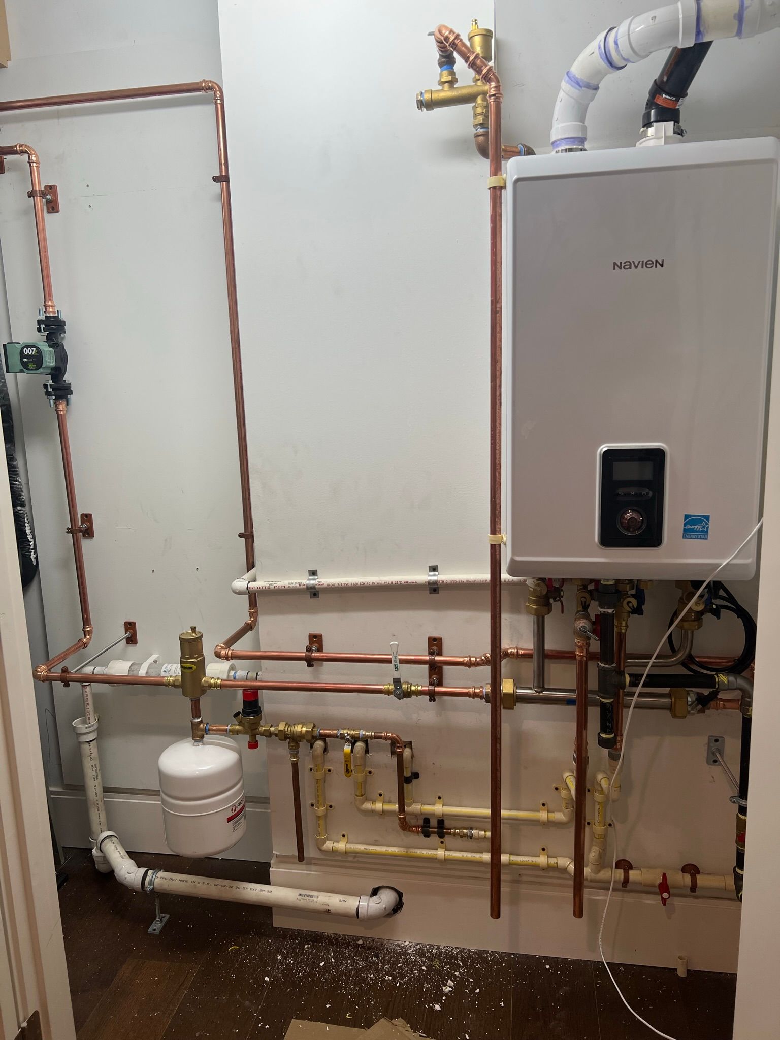 a room with a boiler and copper pipes on the wall