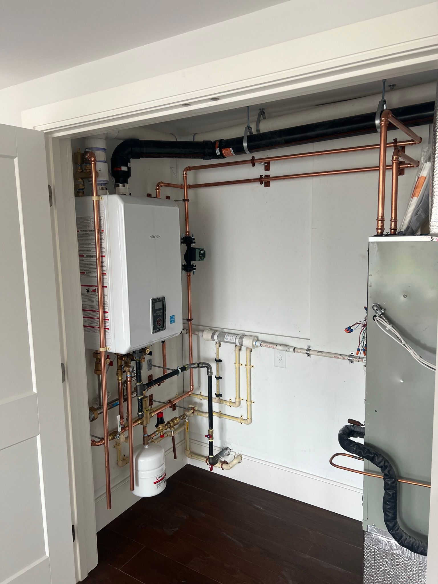 a room with a boiler and copper pipes in it