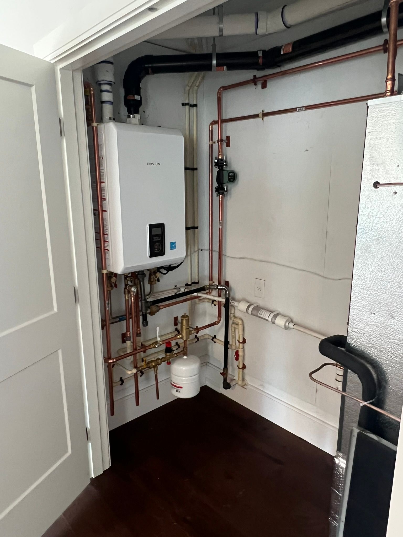 a room with a boiler and pipes on the wall