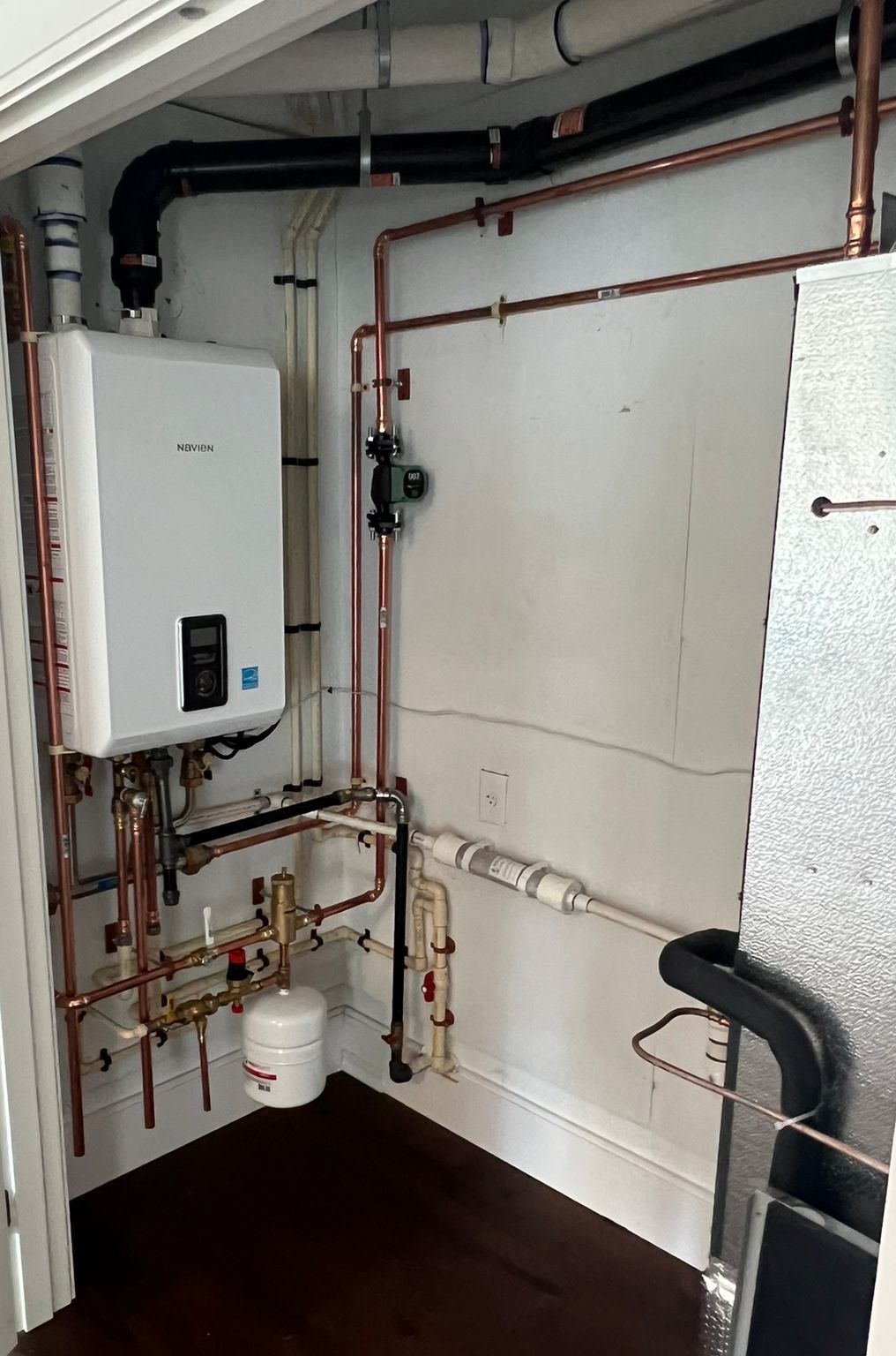 a room with a boiler and pipes in it