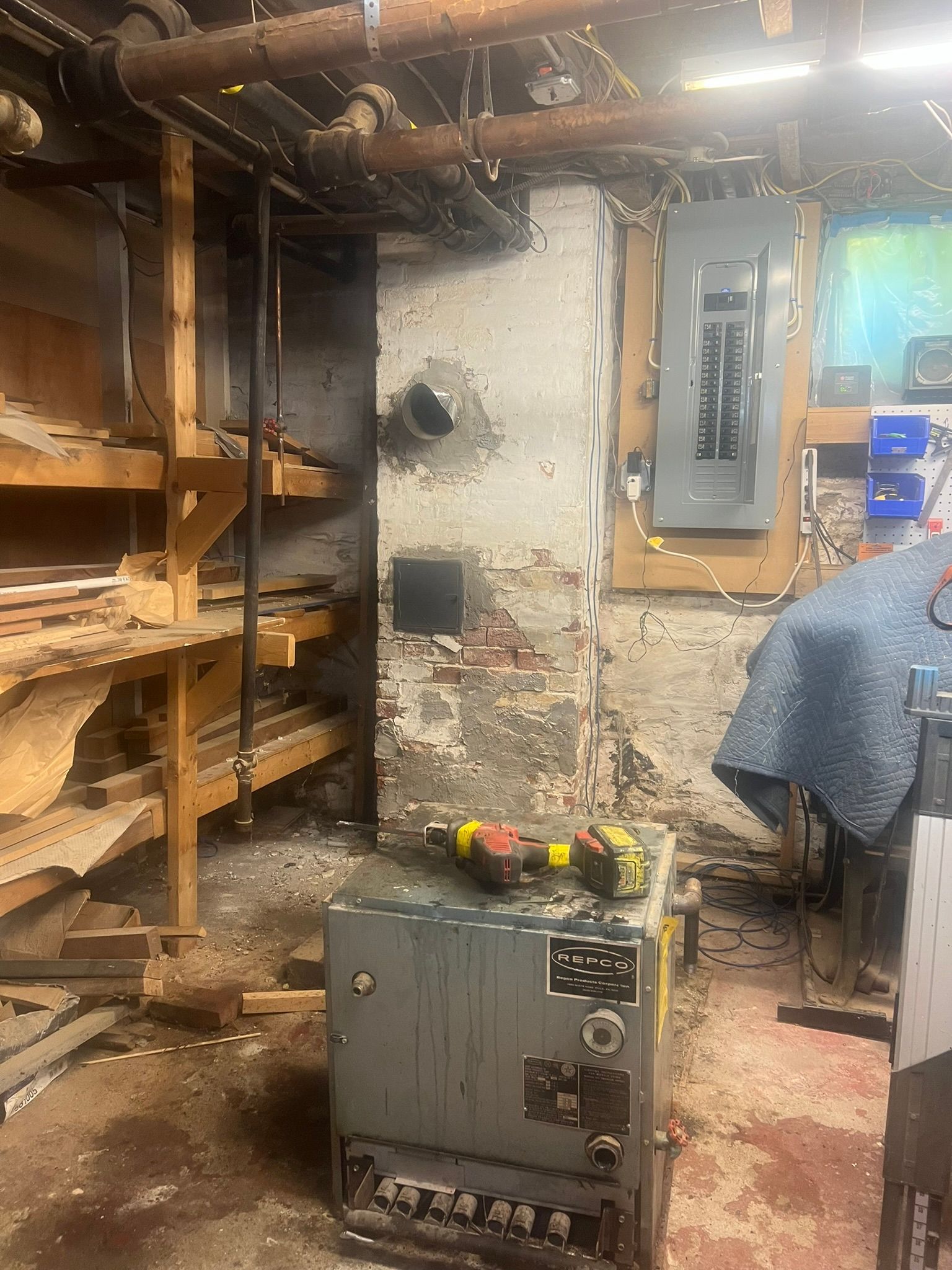 a boiler is sitting in a basement next to a brick wall