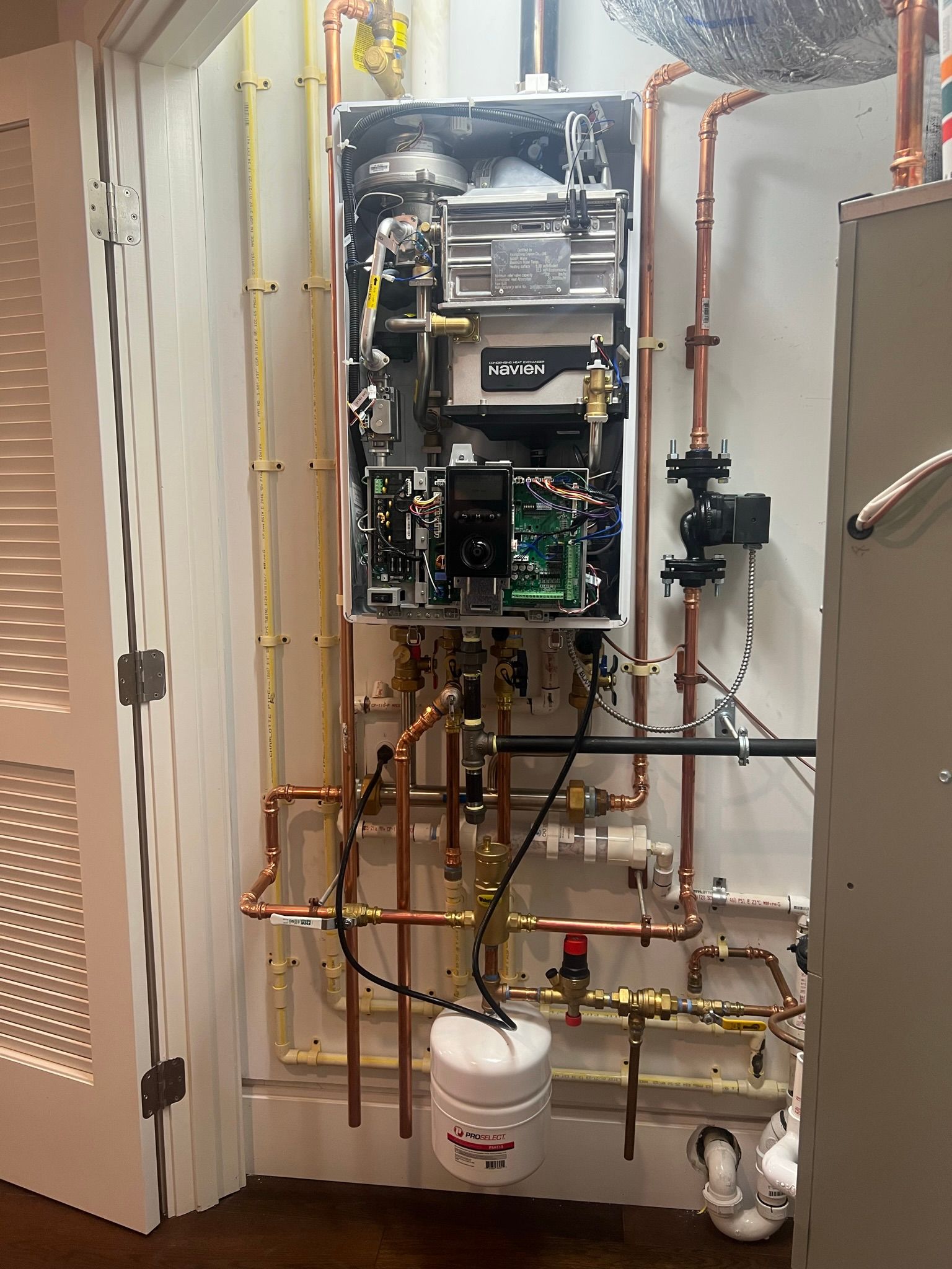 a water heater is being installed in a room with copper pipes