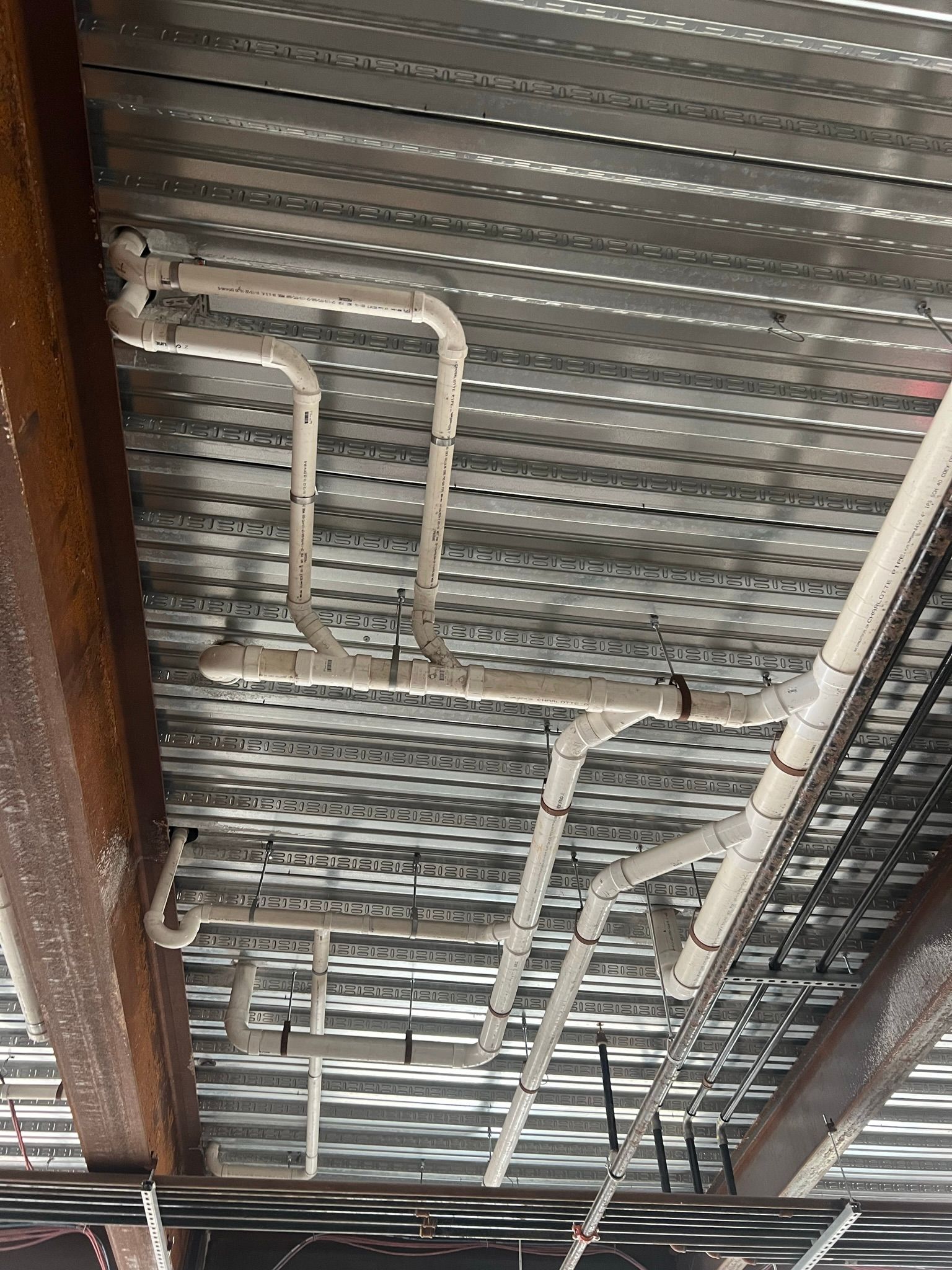 a bunch of pipes are hanging from the ceiling of a building