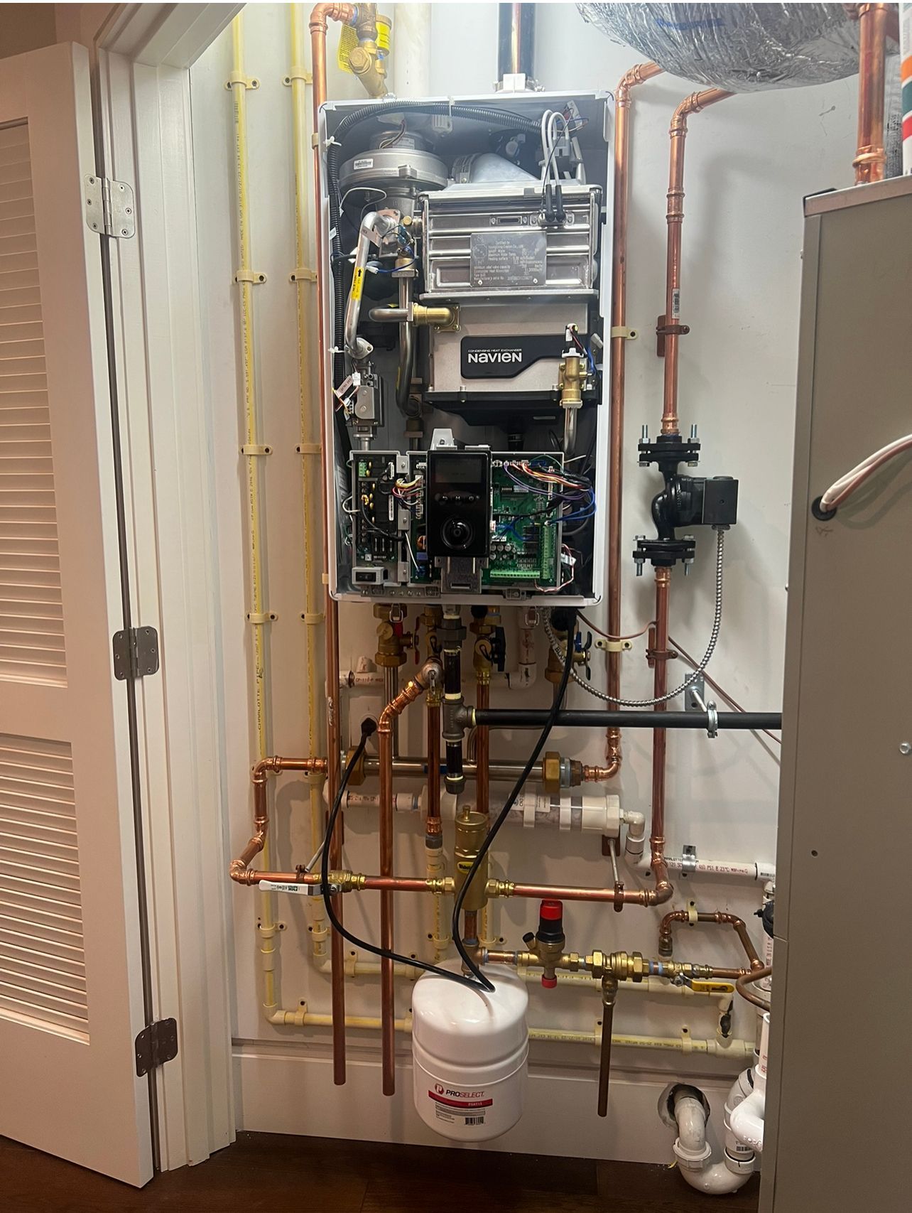 a water heater is being installed in a room with copper pipes