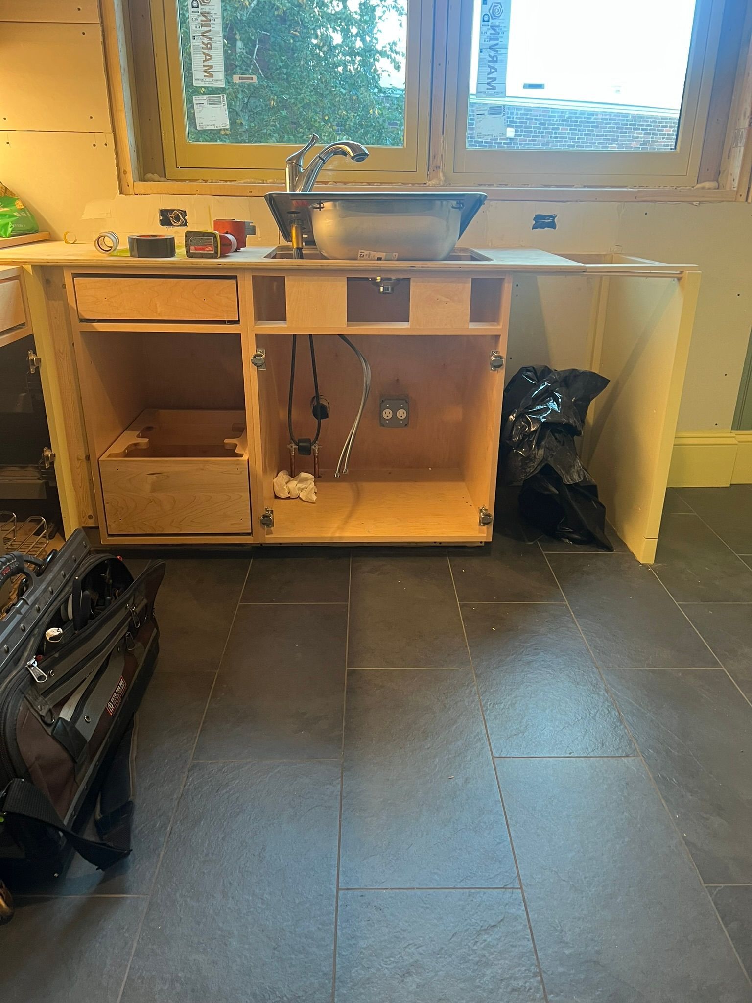 a kitchen sink is being built in a room with a window