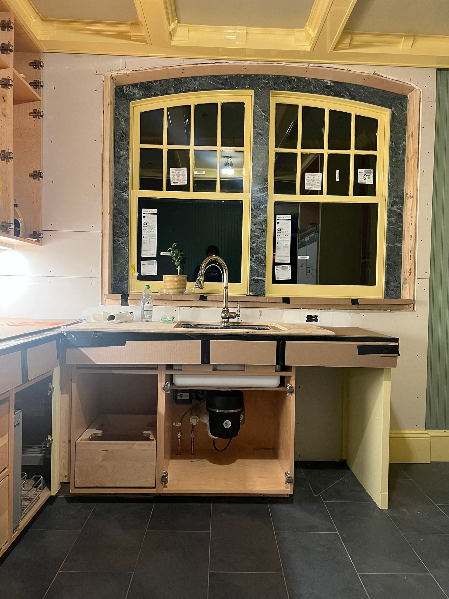a kitchen under construction with a sink and a window