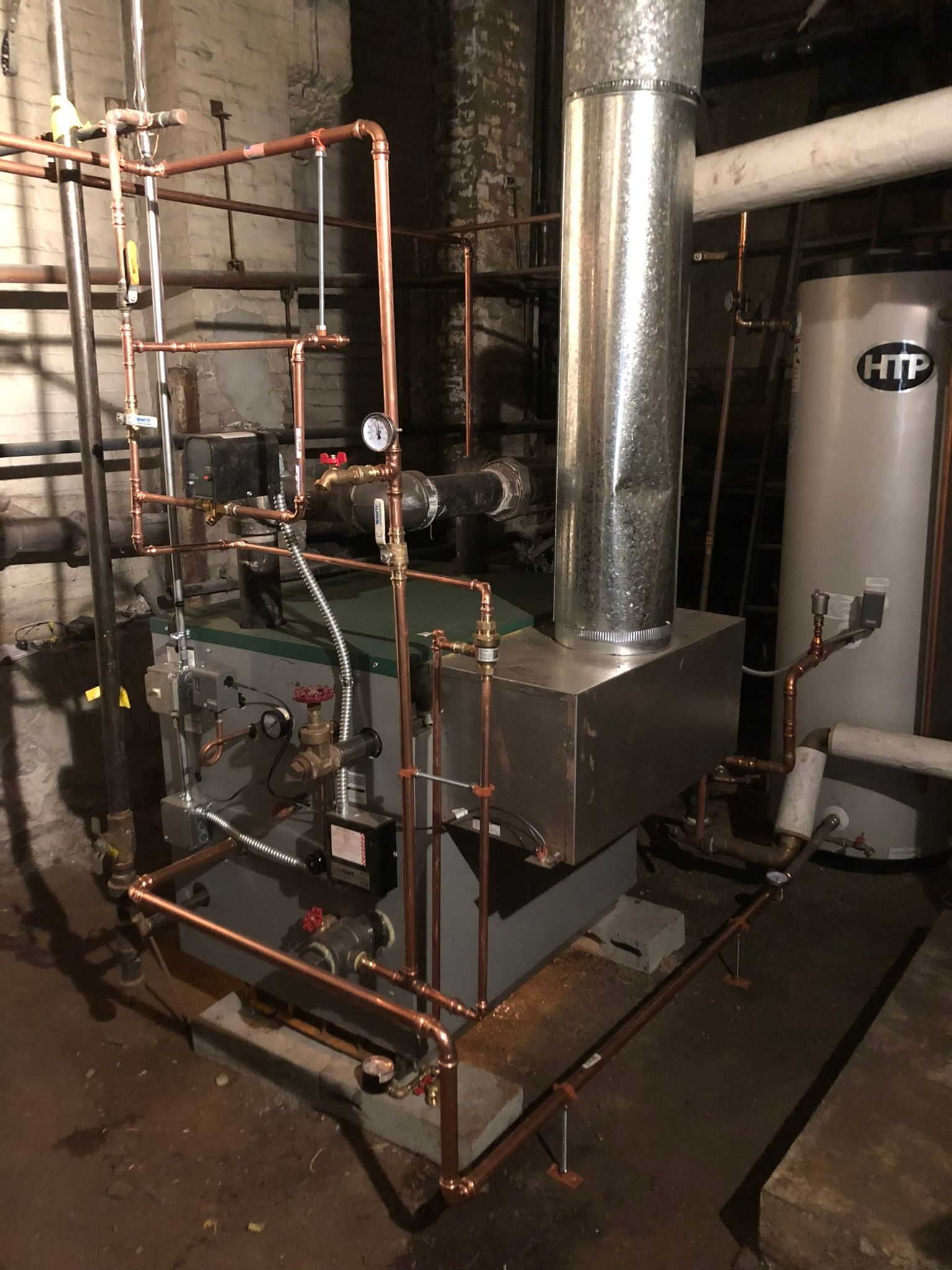a boiler is sitting in a basement next to a water heater