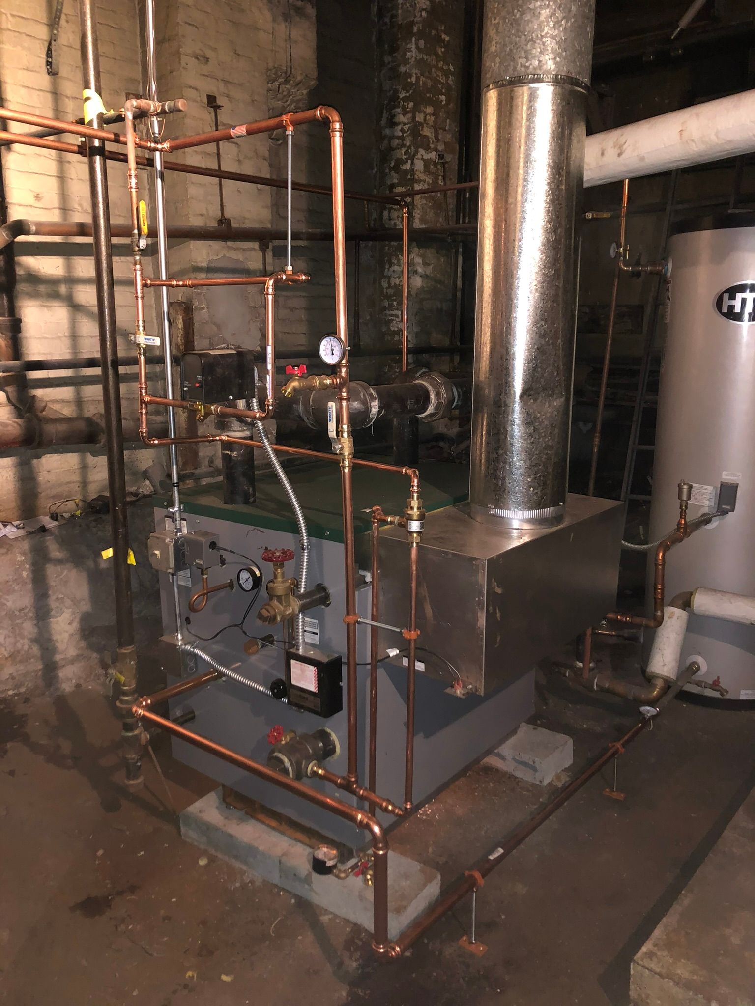 a boiler is sitting in a basement next to a water heater