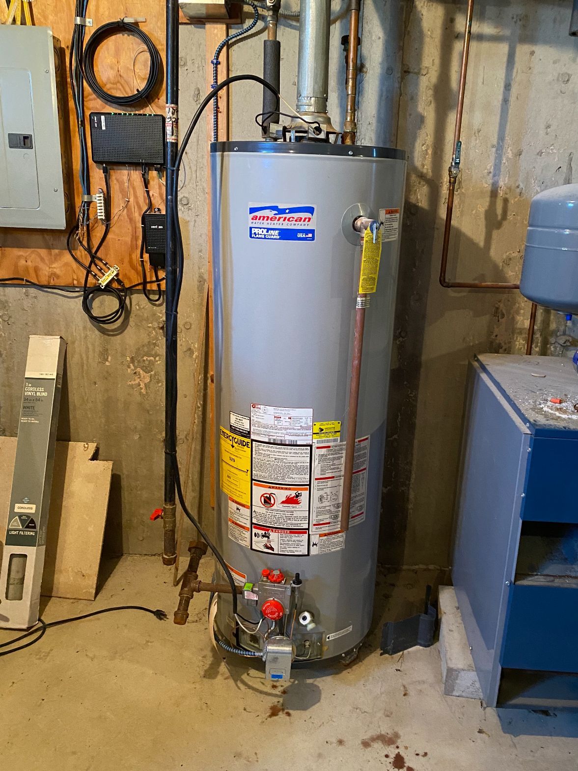 a water heater is sitting in a basement next to a wall