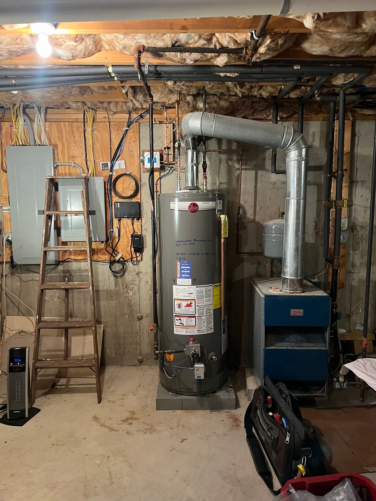 a basement with a water heater and a stove