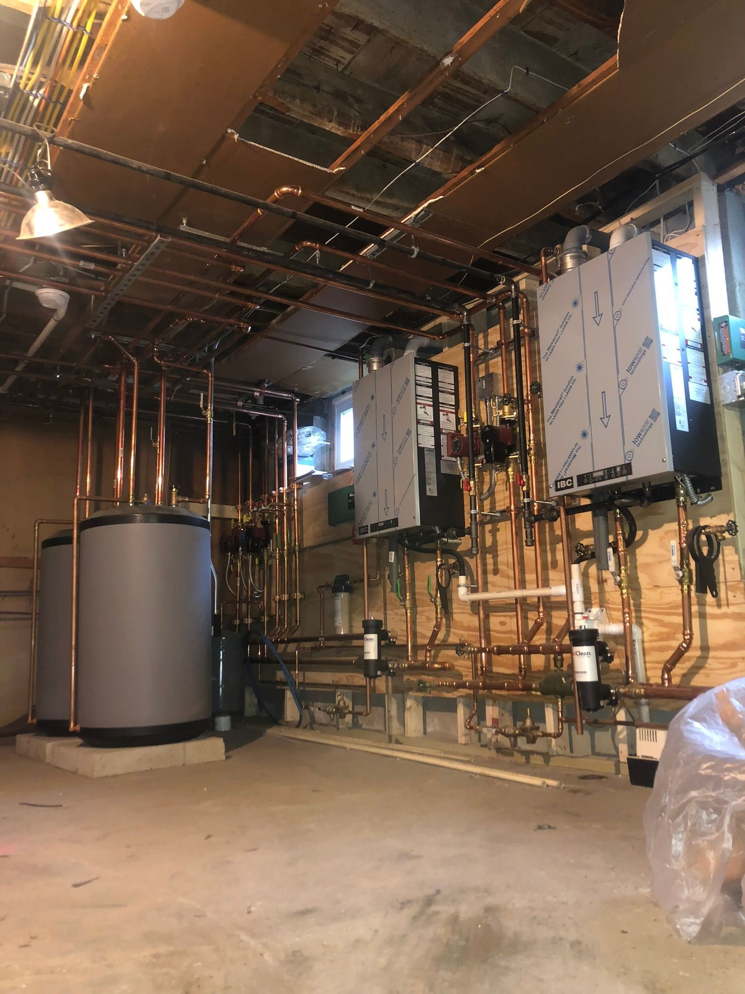 a room with a lot of pipes and a ladder in it