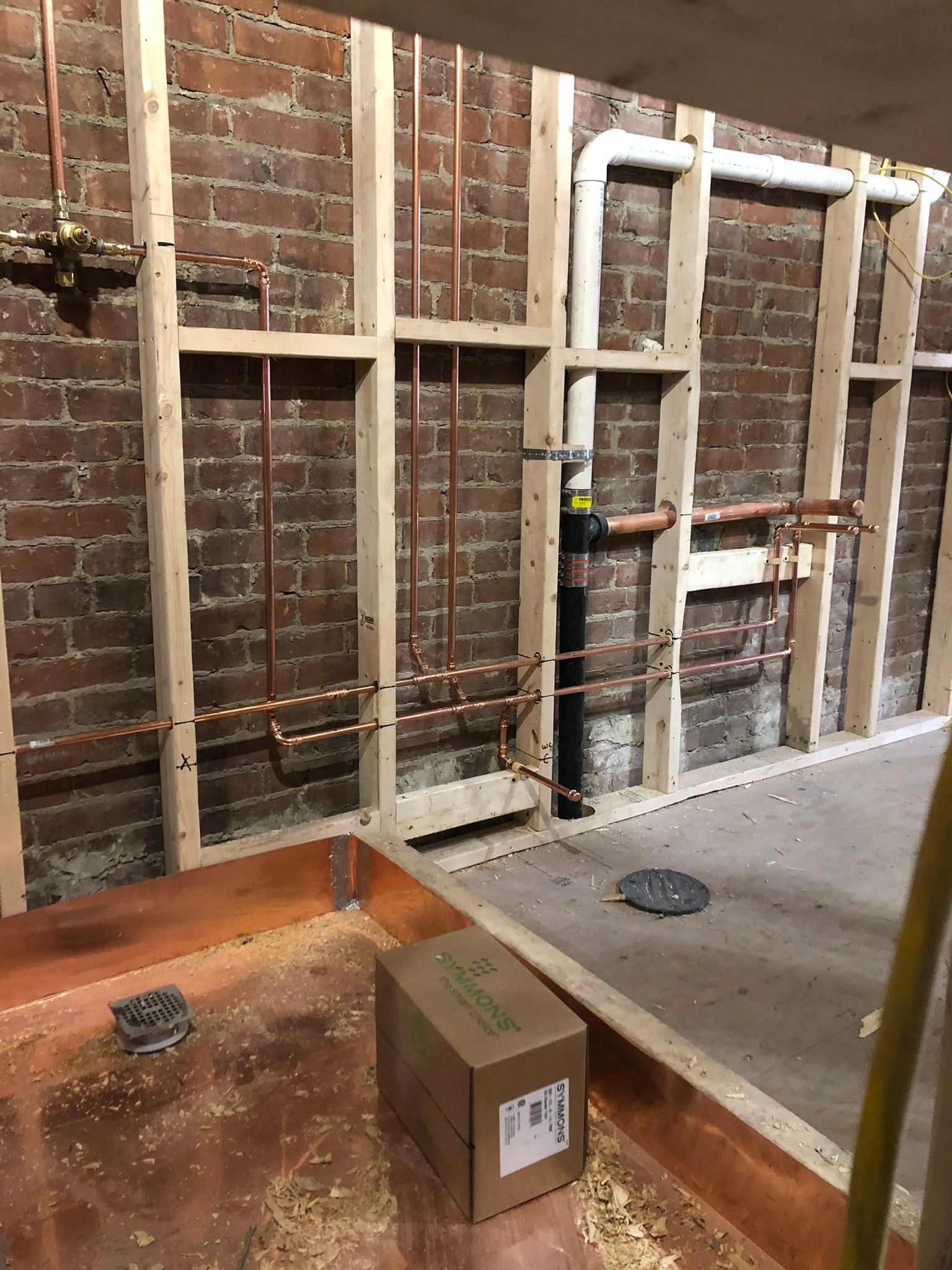 a box is sitting on the floor in front of a brick wall