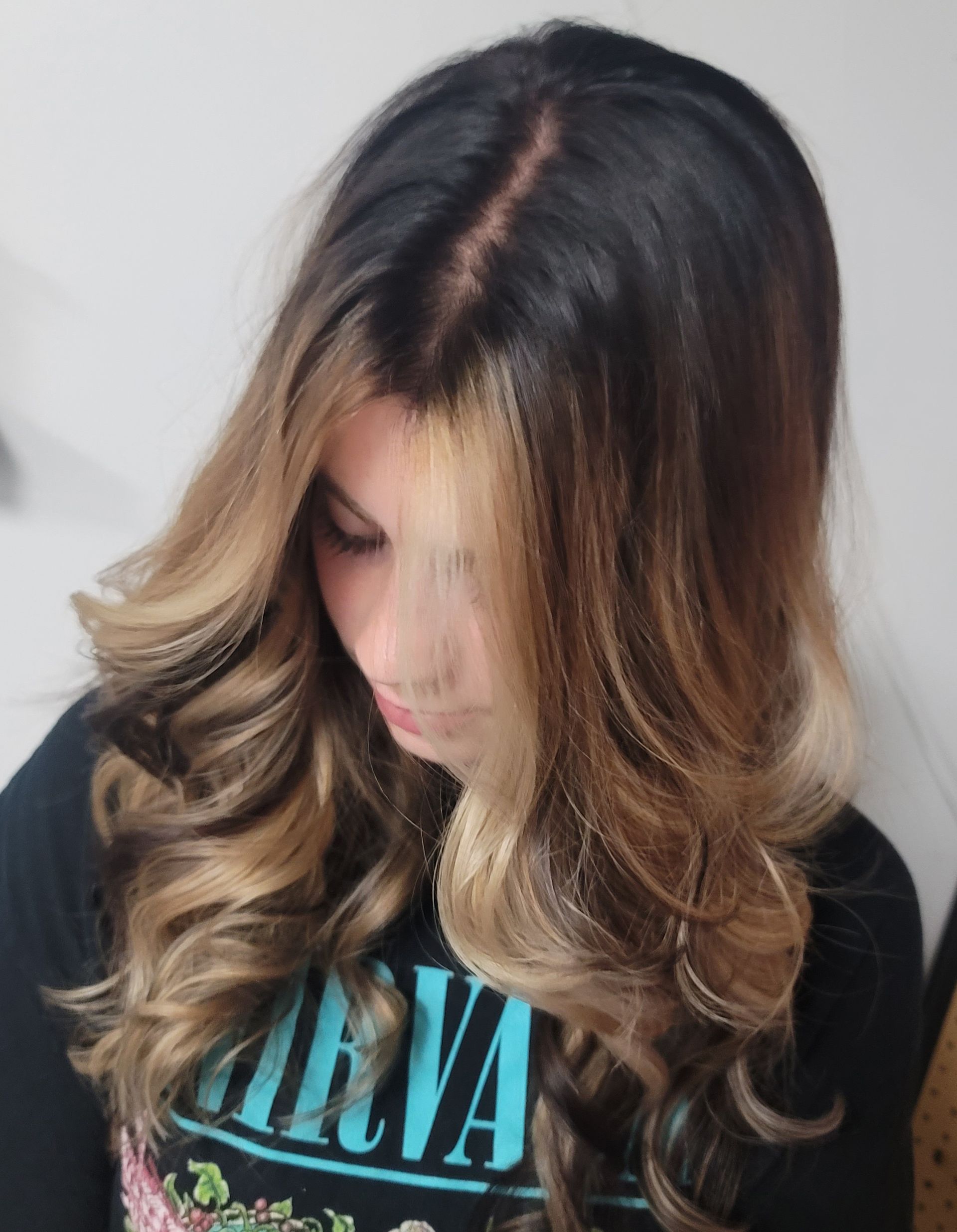 A woman with long hair is wearing a nirvana shirt