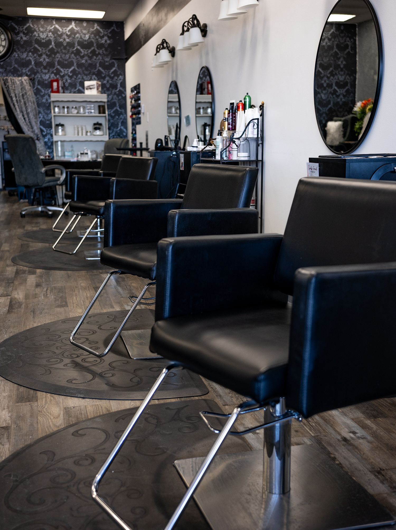 A row of black chairs in a hair salon